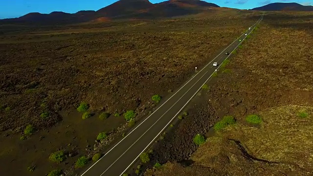 无人机在兰萨罗特岛上空拍摄的航拍镜头，以提曼法亚国家公园为背景，拍摄了令人惊叹的火山景观和黑土地上令人惊叹的长直道。4 k UHD。视频素材