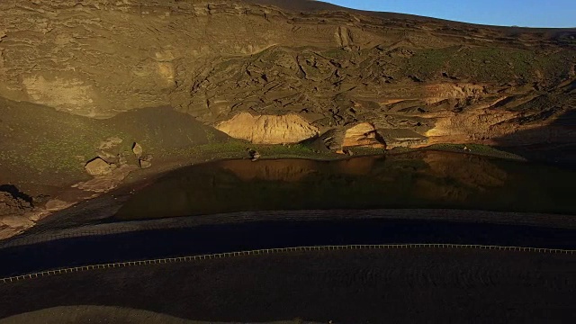 无人机在火山兰萨罗特岛上空拍摄的航拍画面，岛上的景色令人惊叹，海滩附近还有绿色的los Clicos池塘。4 k UHD。视频素材