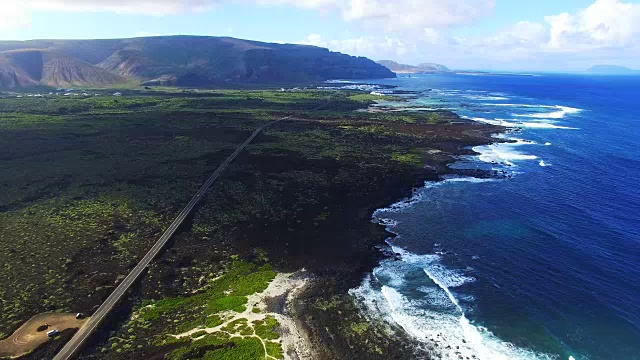 无人机在美丽的兰萨罗特火山岛北部海岸上空拍摄的航拍画面，海岸线上有一条笔直的长路，令人惊叹。4 k UHD。视频素材