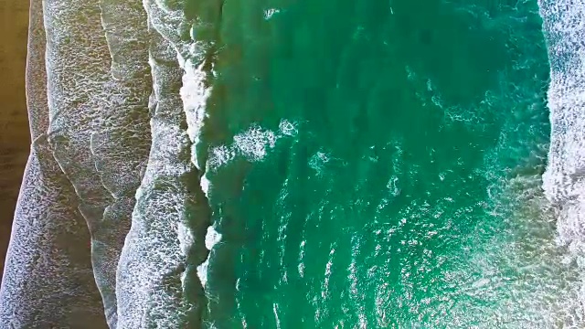 海浪在海滩溅水的鸟瞰图。视频素材