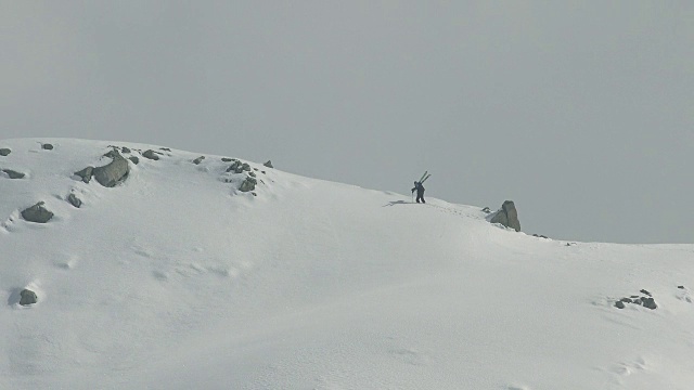 滑雪者在雪地里向山顶走去视频素材