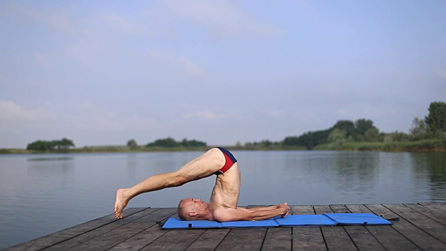 一个男人在湖边做瑜伽视频素材