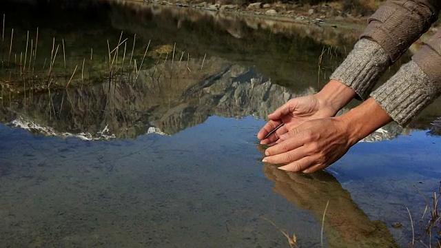 人们用手从湖里舀起淡水视频素材