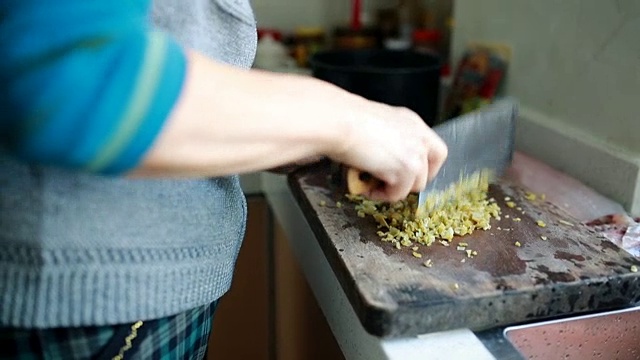 家庭烹饪:一位老年妇女在切蔬菜视频素材