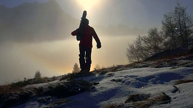 一个滑雪的人在雪山上走着双彩虹视频素材