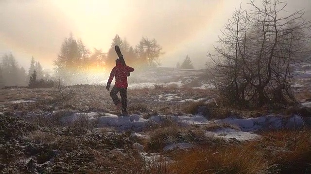 一个滑雪的人在雪山上走着双彩虹视频素材