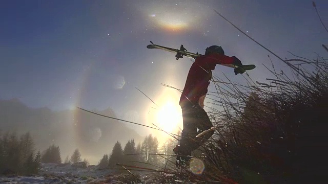 一个滑雪的人在雪山上走着双彩虹视频素材