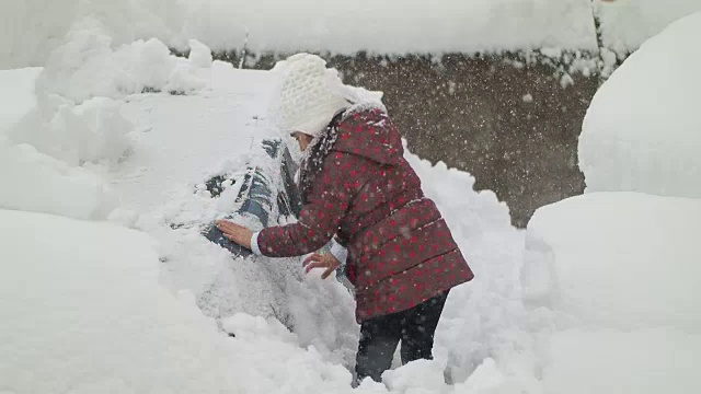 小女孩在清理雪和车视频下载