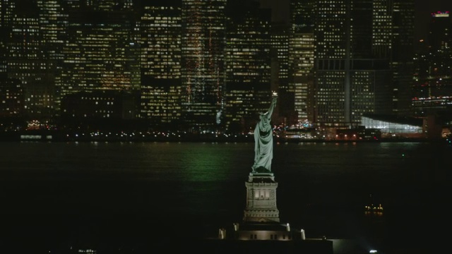 AERIAL MS View of statue of liberty at night with nick in background /纽约市视频素材