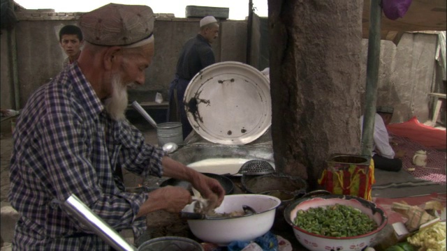 中国新疆喀什，一名男子在市场上准备食物视频素材