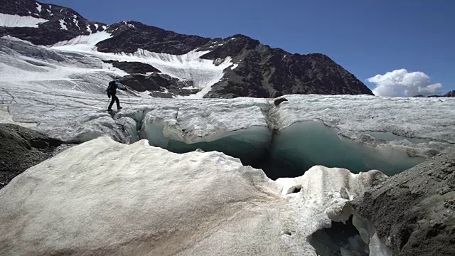 徒步旅行者在冰川上走到山顶视频素材