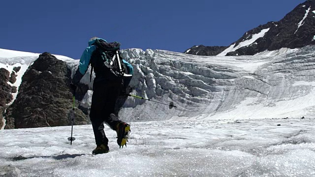 徒步旅行者在冰川上走到山顶视频素材