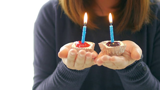 生日纸杯蛋糕与蜡烛在女人的手庆祝概念视频素材