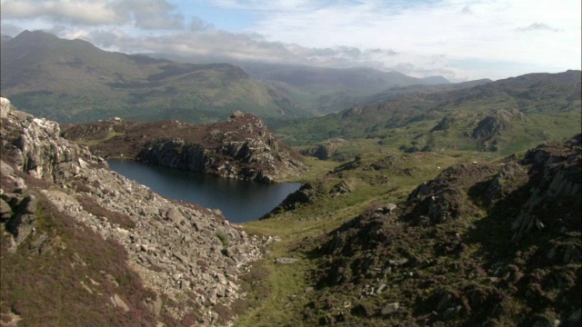 在英国威尔士斯诺登尼亚的石南、峭壁和山湖上的空中视频素材