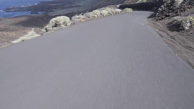 有弯道的空路。开车/过程盘子。西班牙加那利群岛的火山景观，以大海为背景。视频素材