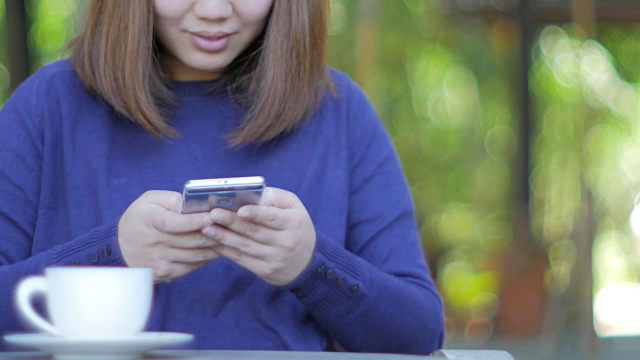 女人触摸和使用智能手机在室外场景与咖啡在放松时间视频素材