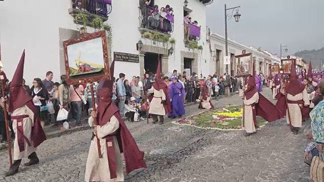 危地马拉安提瓜的天主教大斋节复活节游行。身穿传统紫色和带帽服装的人们抬着的雕像视频素材