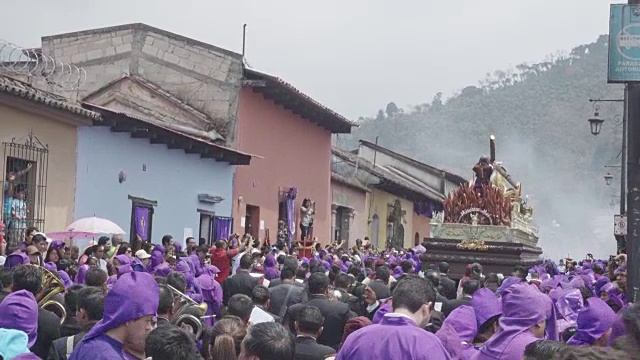 危地马拉安提瓜的天主教大斋节复活节游行。身穿紫色和黑色传统服装的人们抬着的雕像视频素材