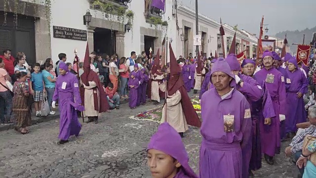 危地马拉安提瓜的天主教大斋节复活节游行。身穿传统紫色和带帽服装的人们抬着的雕像视频素材