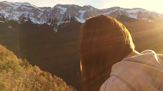 美丽的俄罗斯女孩移动他的长发与美丽的白雪皑皑的比利牛斯山在圣诞节假期旅行在加泰罗尼亚。视频素材