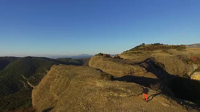 在一次周末旅行中，一名男子在山顶用无人机拍摄了一段航拍镜头，他一边欣赏风景，一边在加泰罗尼亚比利牛斯山脉拍摄照片。视频素材