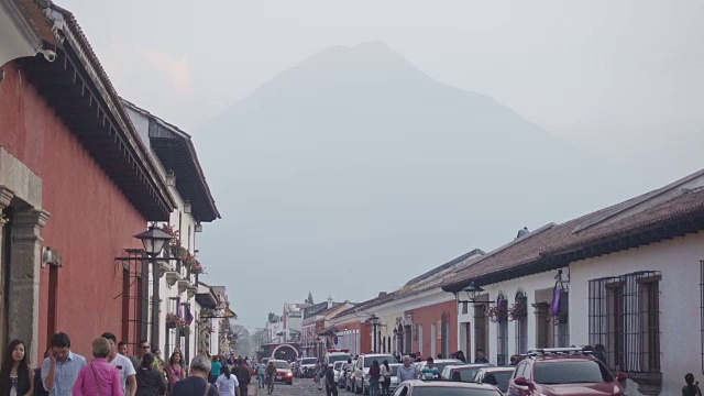 安提瓜瓜殖民时期的街道，背景是人、汽车和一座火山视频素材