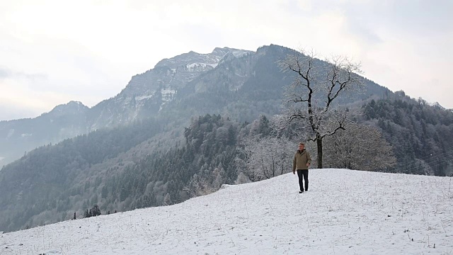 人们从山上被雪覆盖的草地上走下来视频素材