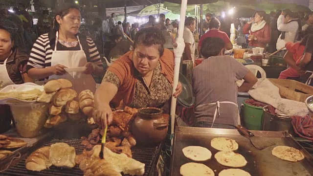 危地马拉安提瓜的街头食品市场。西班牙妇女烹饪烤肉和玉米饼卷视频素材