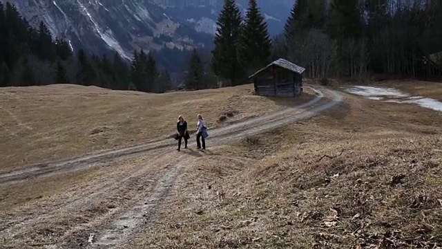 母女俩沿着山间草地的小路往上走视频素材