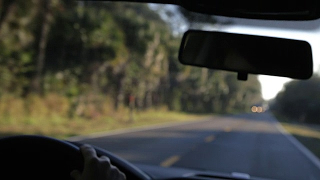 开车/过程盘子。行驶在乡村道路上，关注前景视频素材