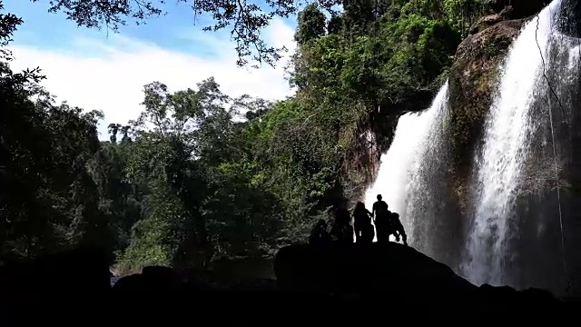 森林深处的瀑布和旅行者视频素材