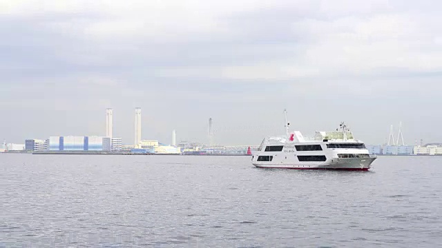 日本神奈川县横滨市的横滨湾。后面可以看到热电站和横滨湾大桥。渡船在海湾上行驶。视频素材