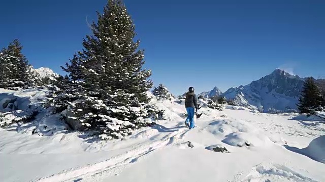 女滑雪板徒步穿越雪地视频素材