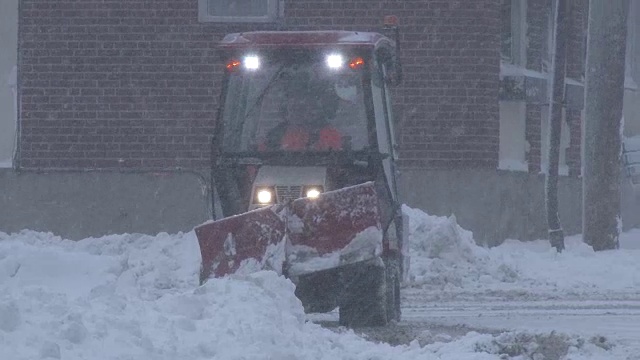 极端暴风雪天气，大雪纷飞，扫雪机清理道路视频素材