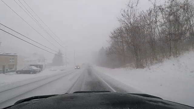 驾驶在暴风雪，白茫茫的条件，危险的旅行-汽车Dash POV视频素材