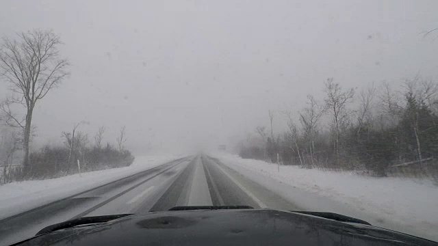 驾驶在暴风雪，白茫茫的条件，危险的旅行-汽车Dash POV视频素材