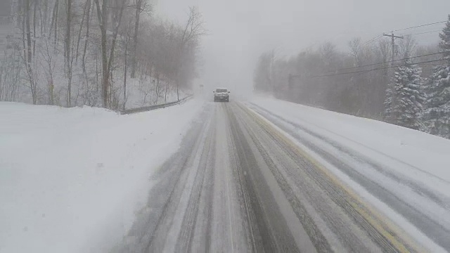 驾驶在暴风雪，白茫茫的条件，危险的旅行-汽车/后方POV视频素材