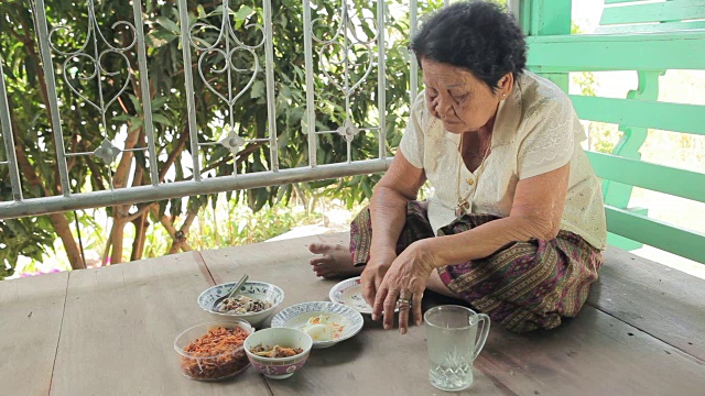 一位年长的亚裔女士正在家里吃午饭视频素材