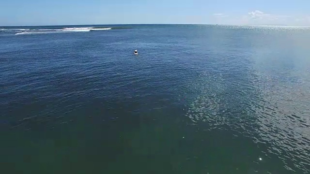 在考艾岛这个神秘的冲浪地点，一名男子划着桨去冲浪视频素材