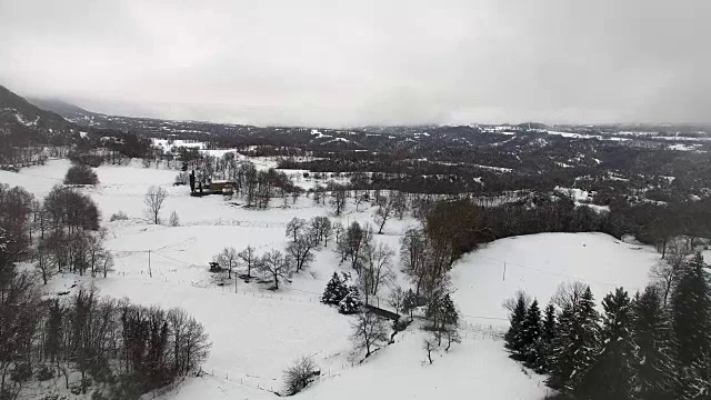 无人机在多云天气下飞过加泰隆尼亚地区下雪的乡村上空拍摄的航拍画面。4 k UHD。视频素材