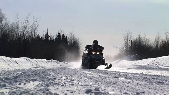 雪地摩托在阿拉斯加结冰的道路上行驶视频素材