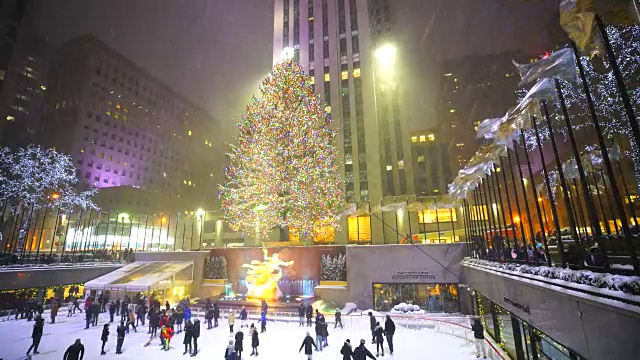 照相机捕捉到了人们在曼哈顿中城洛克菲勒中心的溜冰场享受雪夜滑冰的情景。视频素材