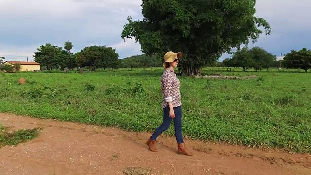 年轻女子走在一条土路上视频素材