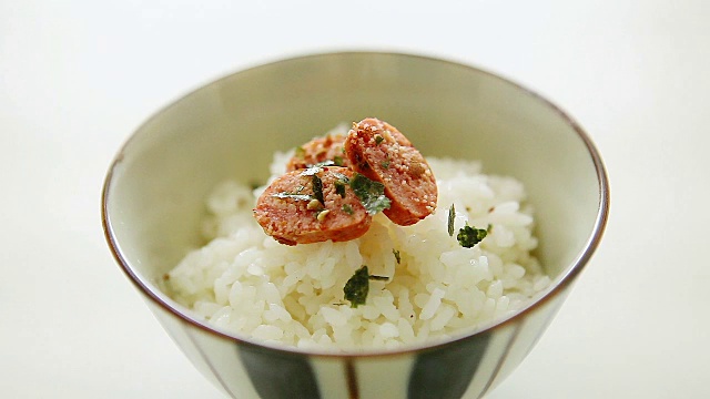 将佐料洒在带有鳕鱼子的米饭里(俗称茶花，这是一种日本食物)视频素材