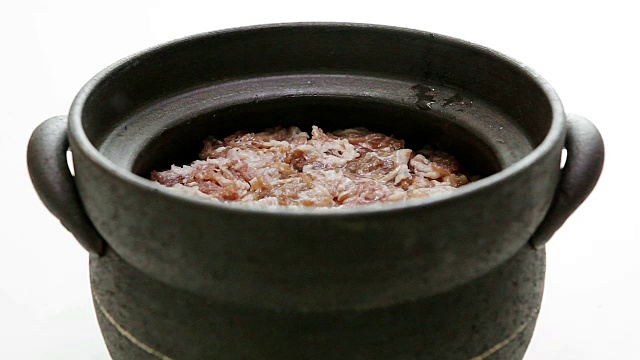 往石锅里倒水，加入生肉和米饭(Sogogimudolsotbap牛肉萝卜石锅饭的制作过程)(韩国传统食物)视频素材