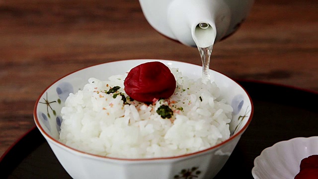 把绿茶倒进碗里(茶花米饭加调味茶水和日本杏子(日本传统食物))视频素材