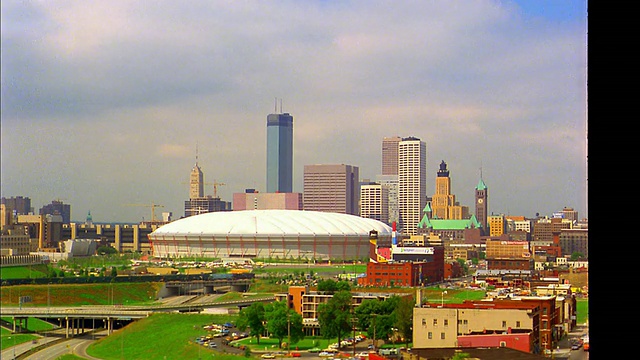 宽镜头延时云在Metrodome +明尼阿波利斯天际线上滚动，前景/ MN高速公路上的交通视频素材