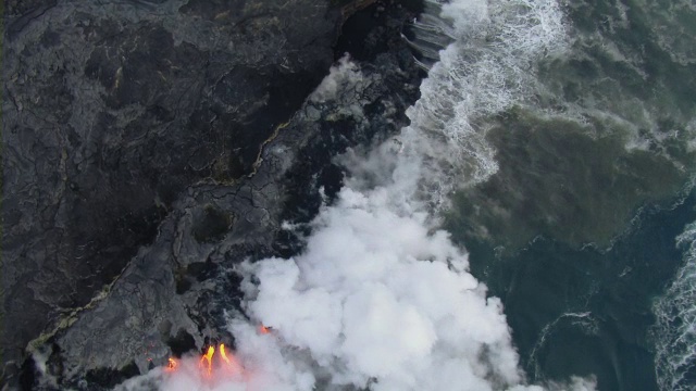 在夏威夷火山国家公园，海浪拍打着炽热的熔岩流。视频素材