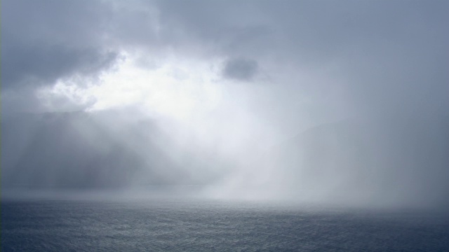 阳光透过云层的鸟瞰图在暴风雨期间在夏威夷莫洛凯怀劳山谷的海岸悬崖视频素材