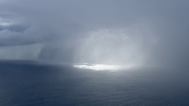 阳光透过雨云和薄雾的鸟瞰图，在夏威夷莫洛凯岛的迈劳山谷海岸。视频素材